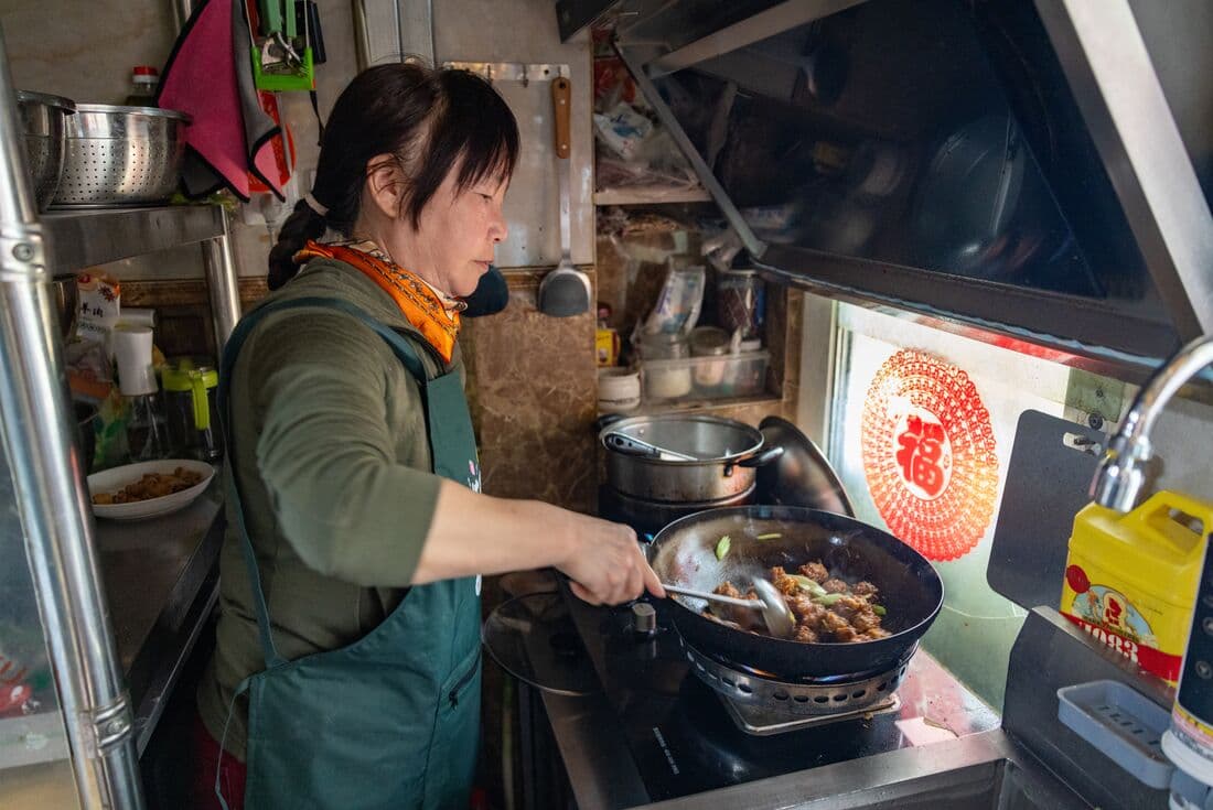 Chef fries up fresh food in a Beijing Hutong, China