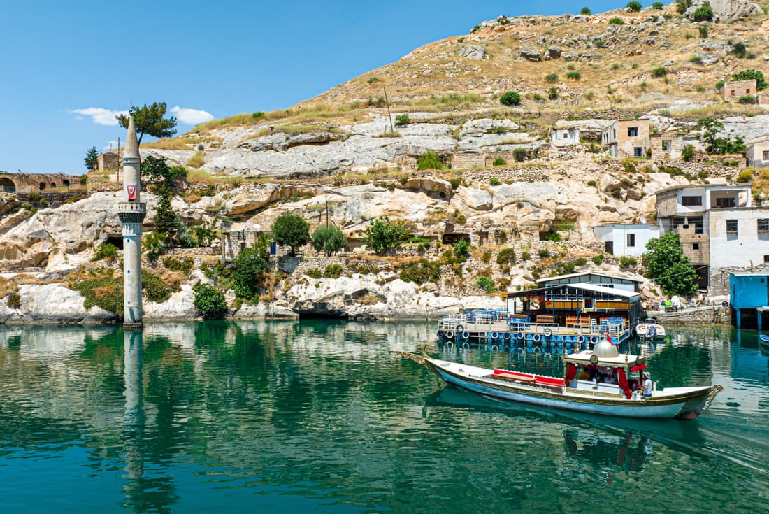 A stylish Turkish gulet moves through the sunken edges of Halfeti village in eastern Turkey