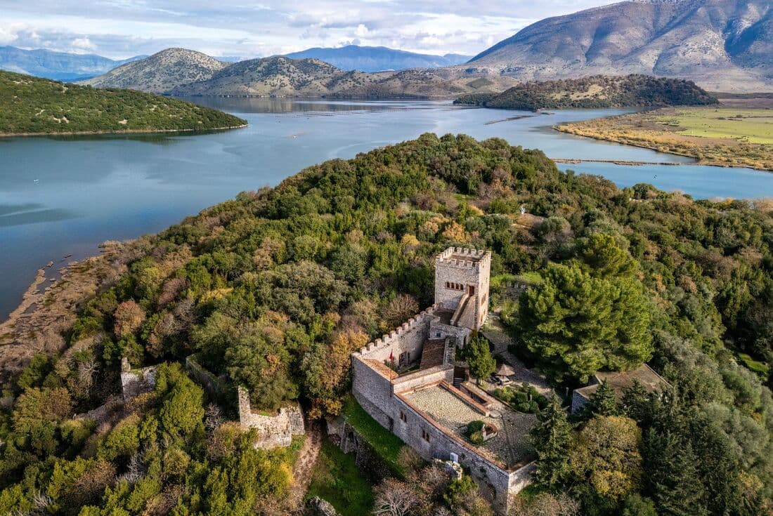 Aerial view of Butrint National Park, Albania, showing a castle, greenery and the lake