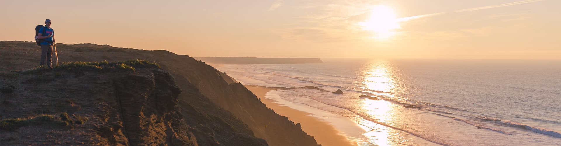 Traveller hiking along coastline of Rota Vicentina at sunset, Portgual