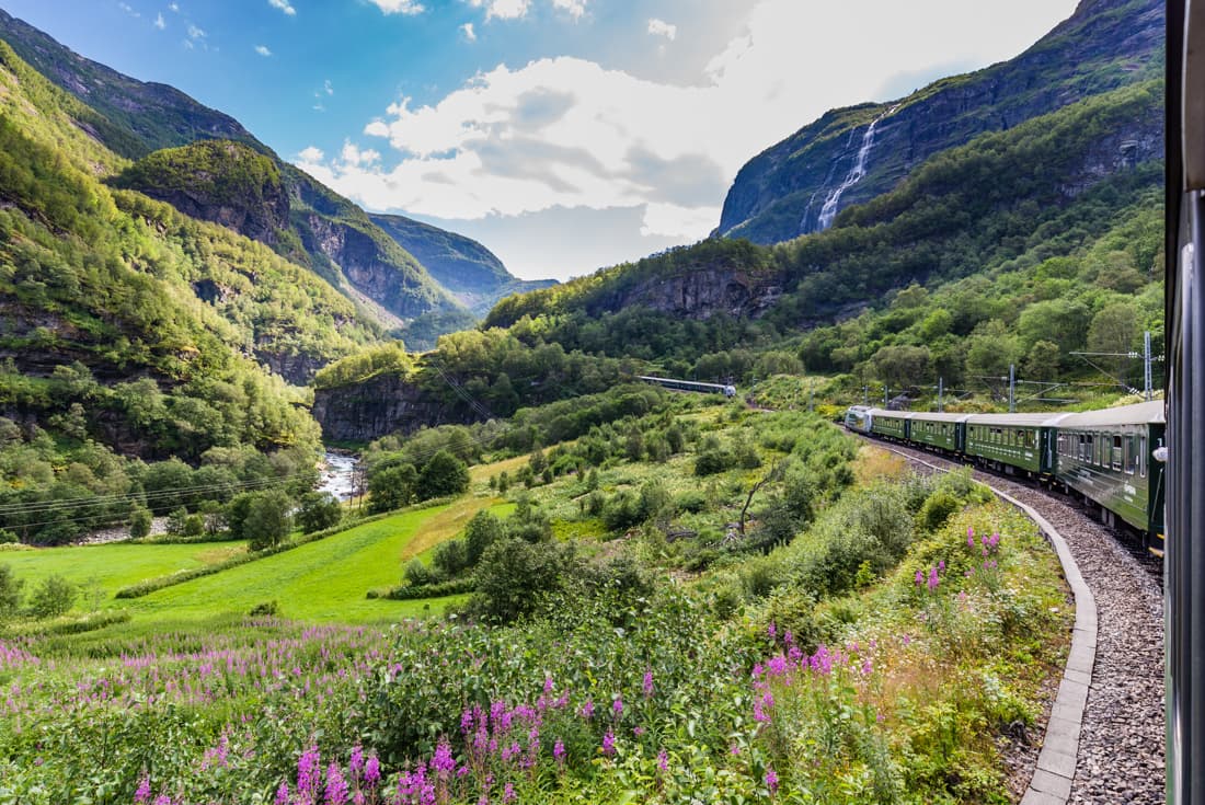 Flamsbana railway train curls through majestic view between fjords in Norway