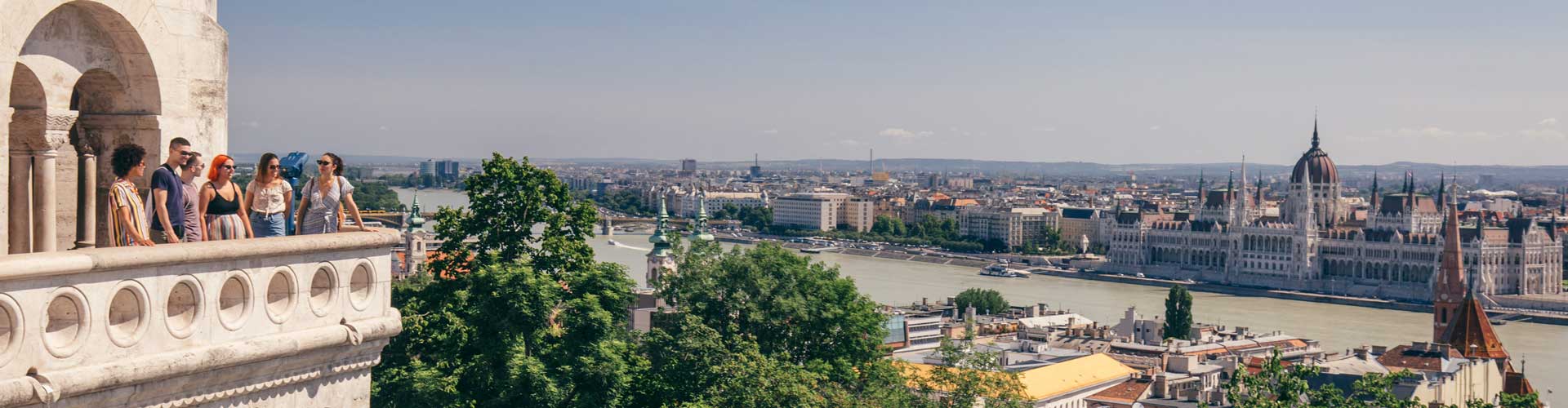 Tour group on balcony looks over river between Buda and Pest