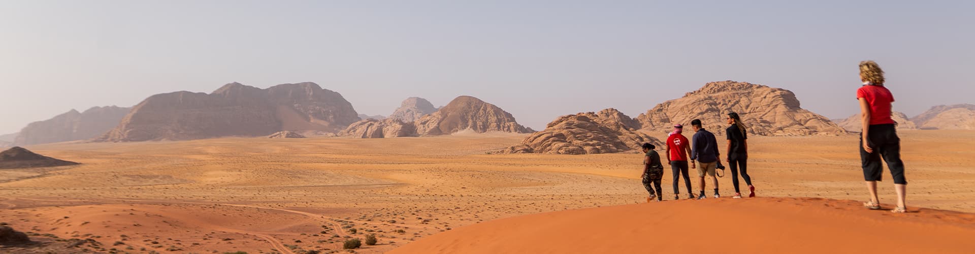 XEPJC - Group walking through desert and sand dunes, Wadi Rum