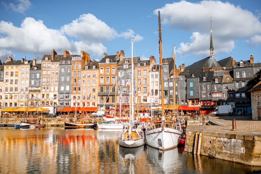 Boats in the water at the harbour in Honfleur with buildings in the background, Normandy, France