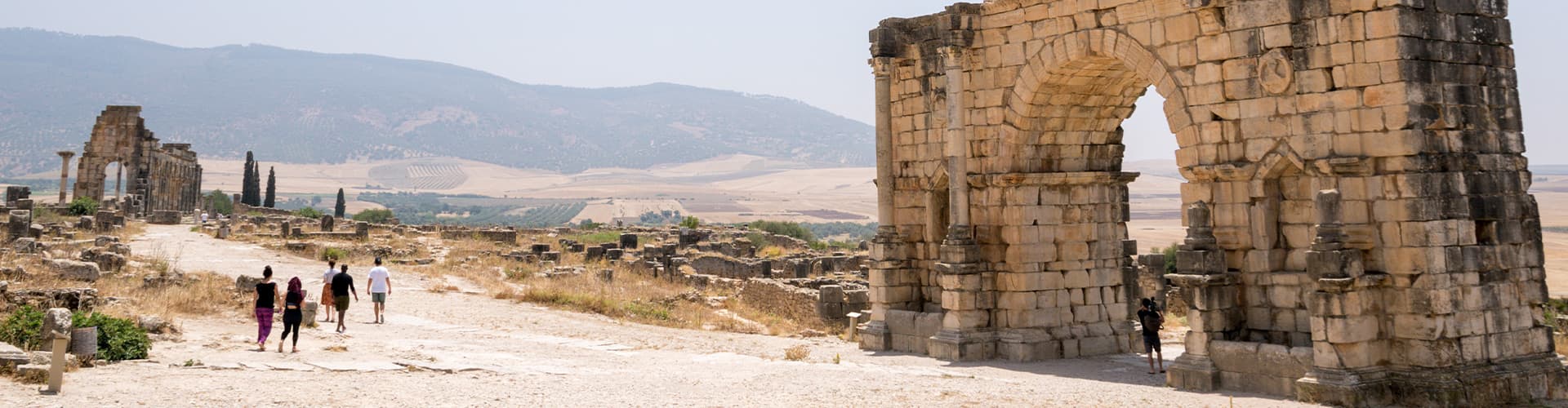 XMPSC - Group of travellers walking through Volubilis ruins, Morocco