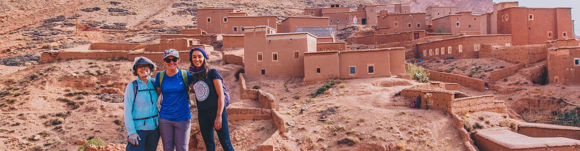 Group of travellers standing before Ait Benhaddou fortified village, Morocco