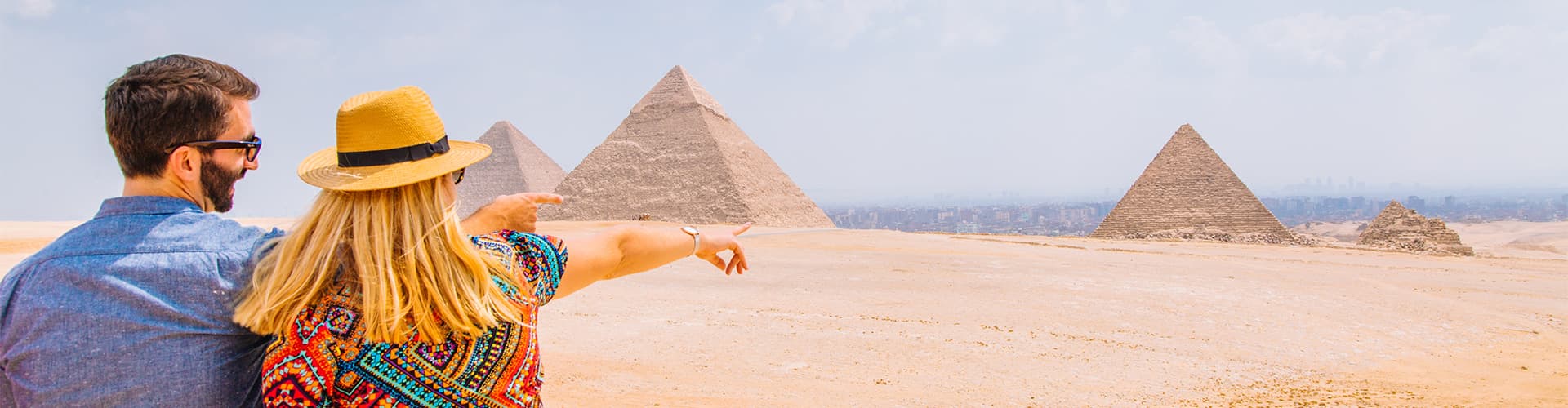 Two travellers look out over the Gisa Pyramids, Egypt