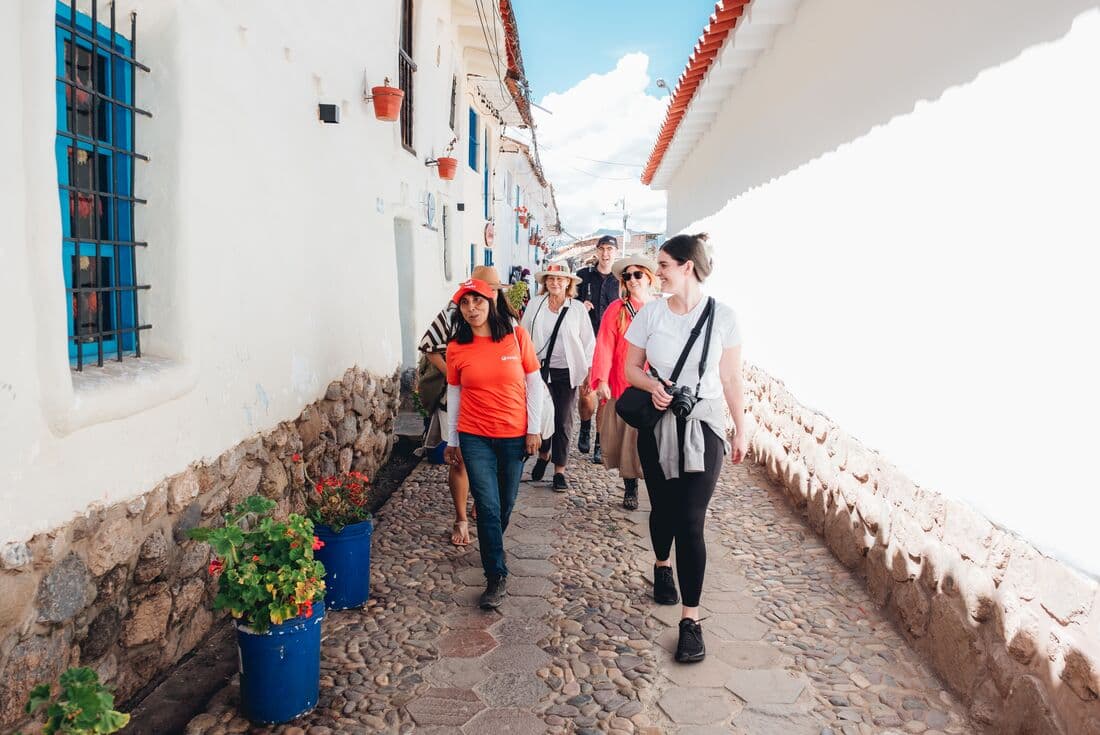 Group of Intrepid travellers walking through the streets of Cusco with leader.