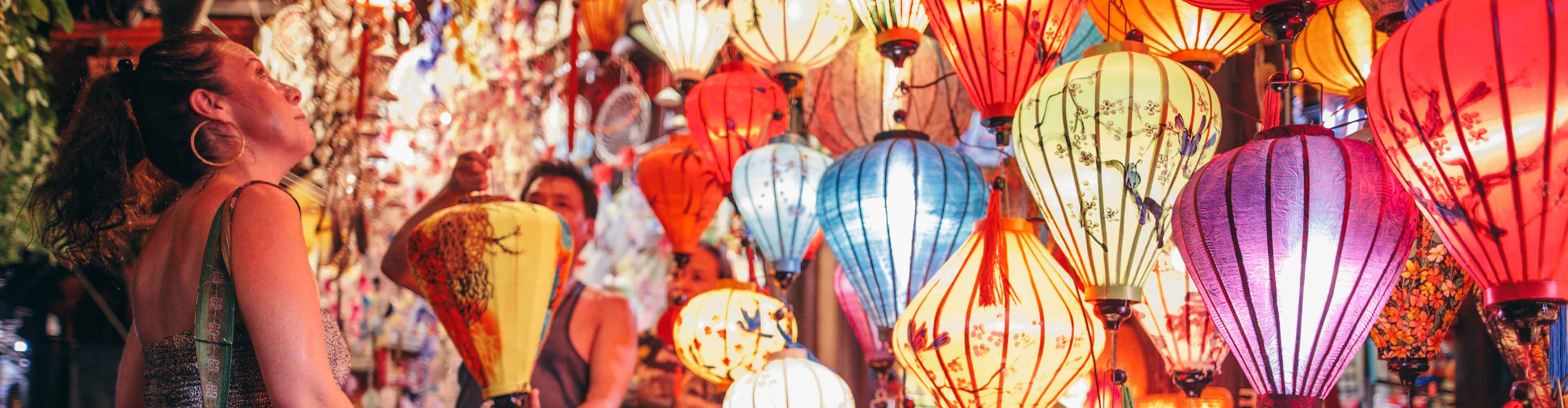 Traveller looks at lanterns at local market in Hoi An, Vietnam