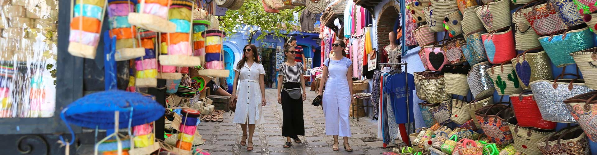 Travellers walking through colourful markets in Chefchaouen, Morocco