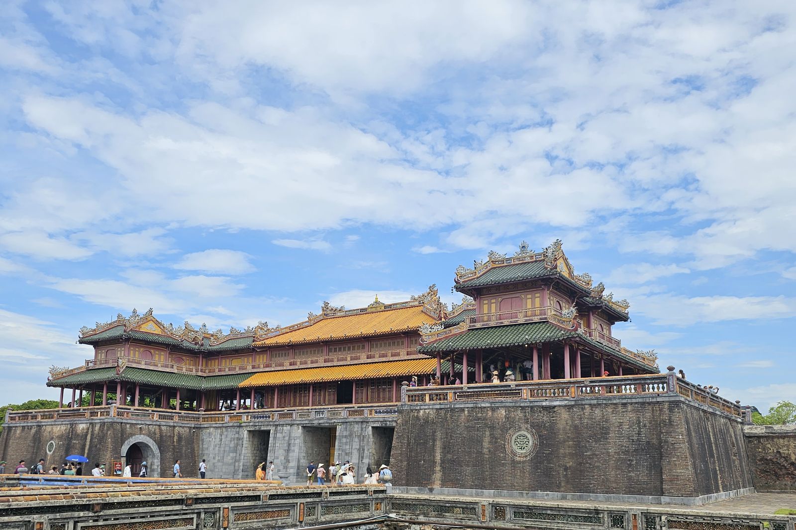 The gatehouse of the Imperial City in Hue, Vietnam, beyond a moat with lotus leaves.